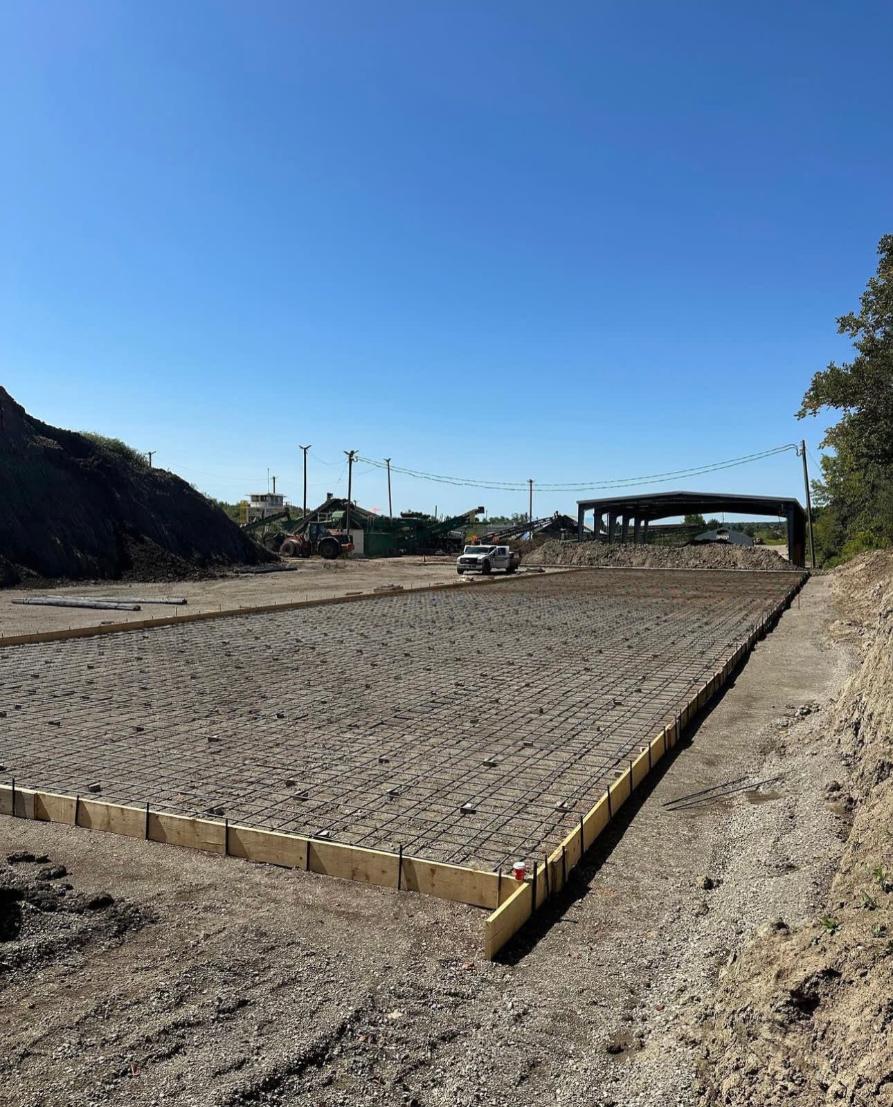 Large reinforced industrial concrete slab formed and tied off with rebar, ready for the pour