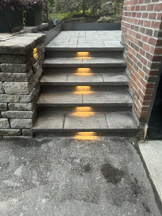 Charcoal ashlar-stamped concrete steps and landing with glowing LED lights set into each riser