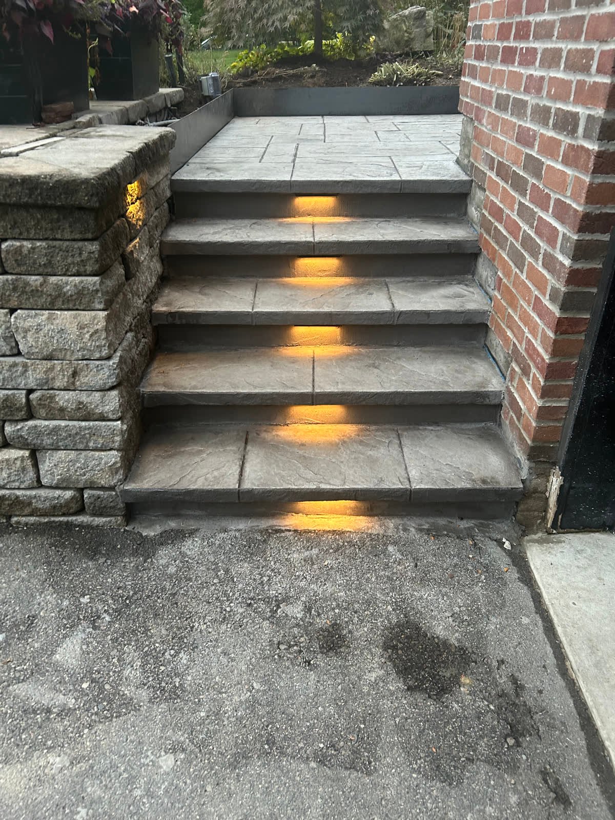 Charcoal ashlar-stamped concrete steps and landing with glowing LED lights set into each riser